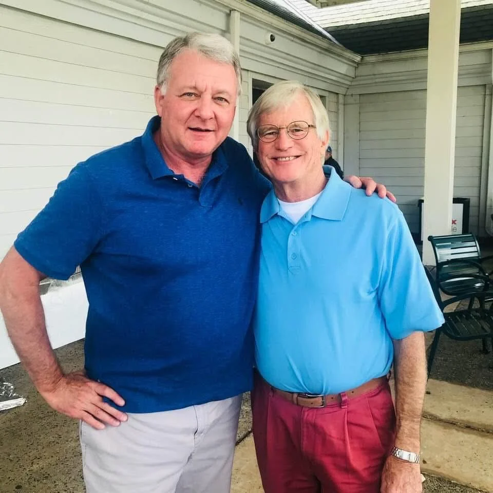 A picture of Walter Williams and Andy Brandham standing side by side, both looking at the camera pleasantly, Walter's hand on Andy's shoulder.
